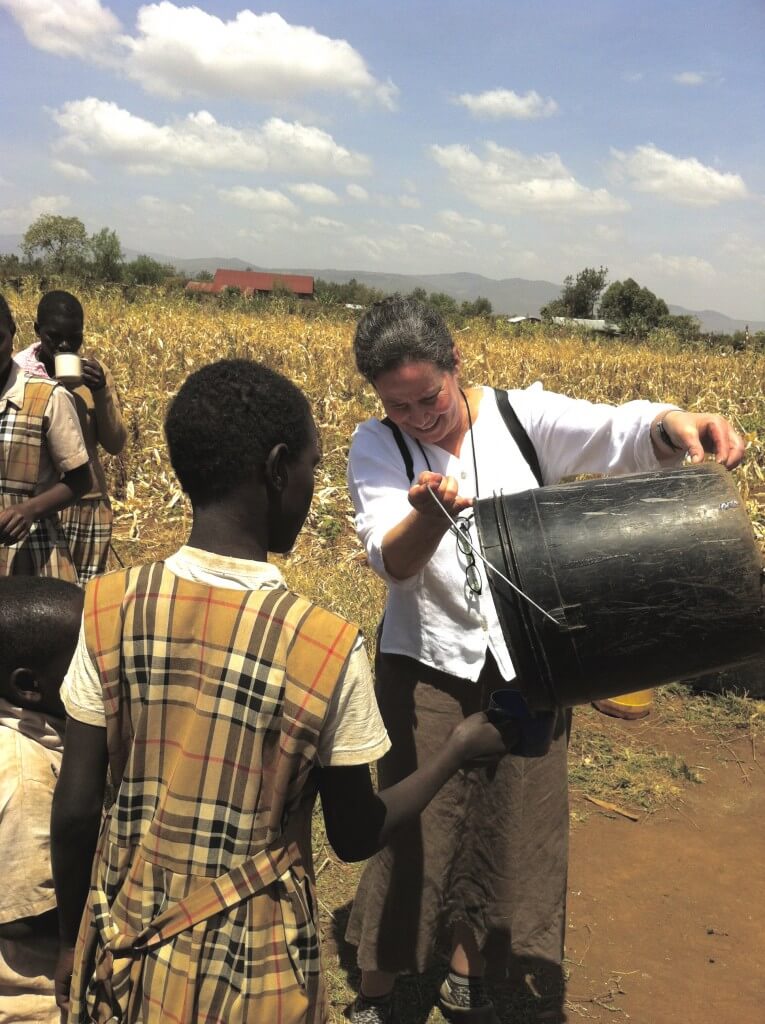an American teacher caring for a child in Kenya
