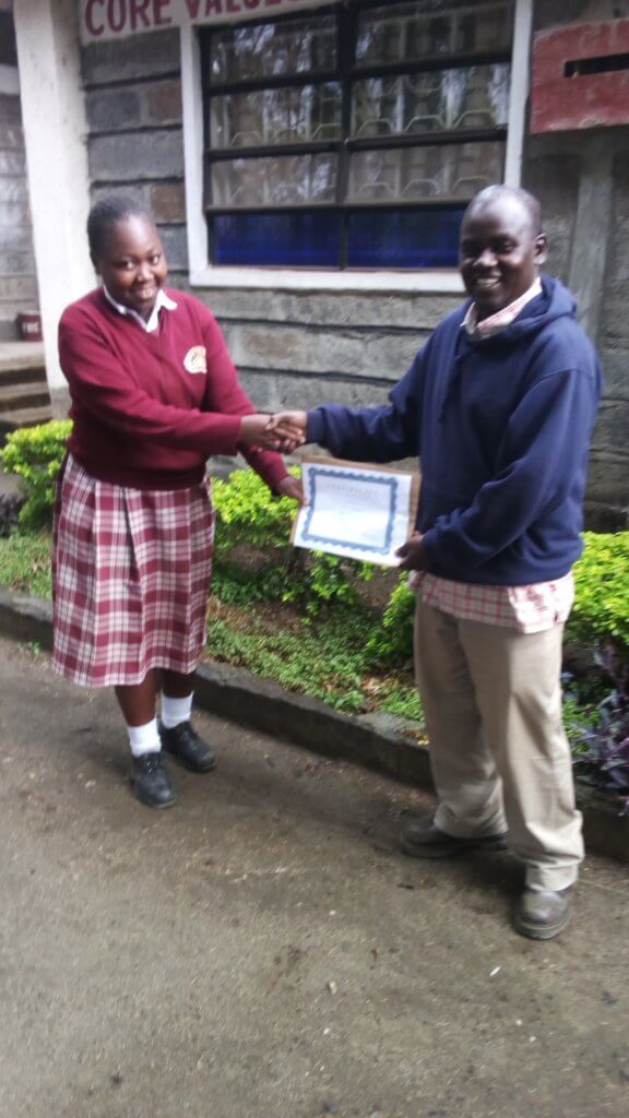 Alice receiving her certificate of completion from William Aludo