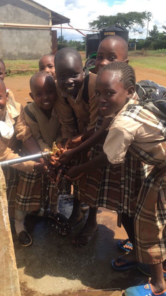 Kenyan school children getting maji (water) from a faucet