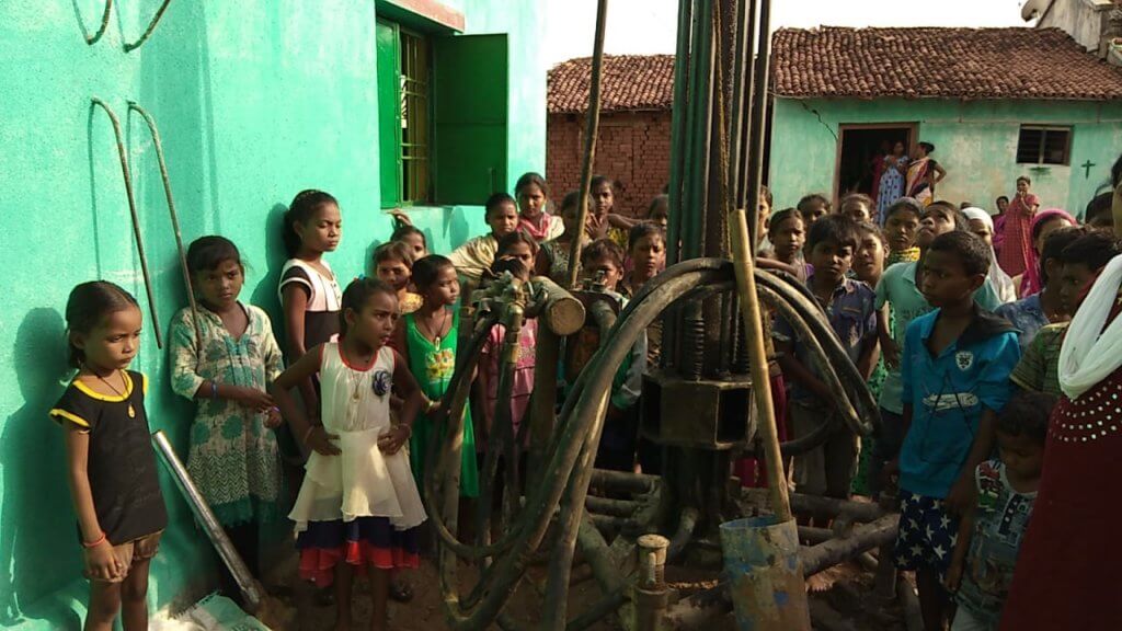 Quenching the thirst of children in India - Waiting by the drill and watching for water