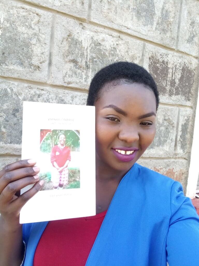 Jedidah with a copy of Jedidah's Journey