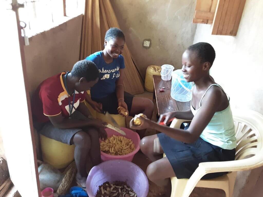 girls peeling potatoes for their fundraiser in Kenya