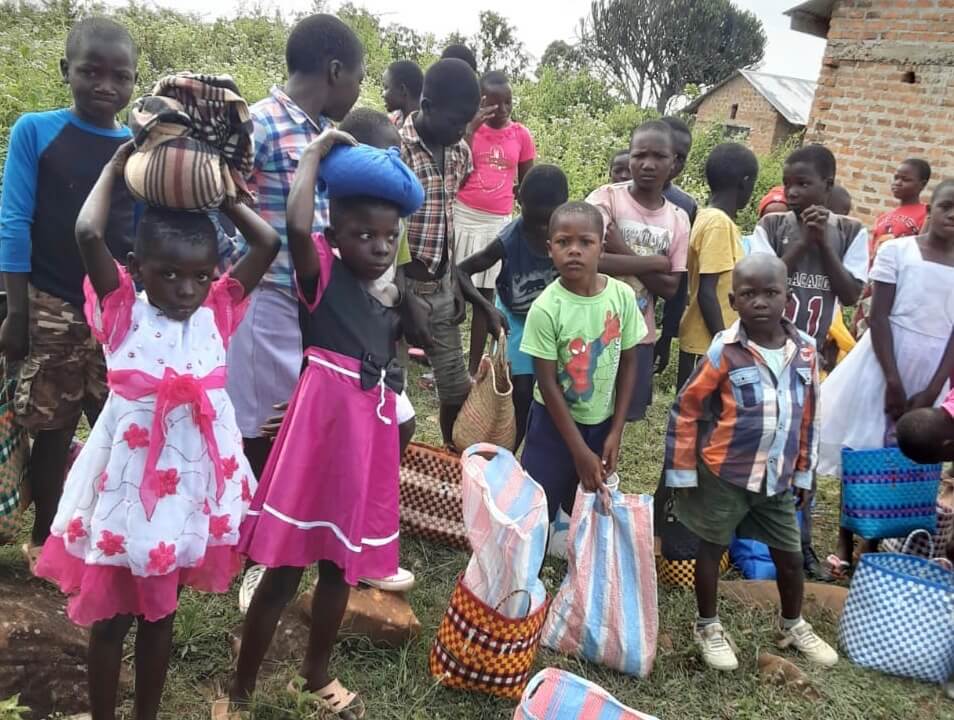 Children with bags of food on their heads are facing a challenging time in Kenya