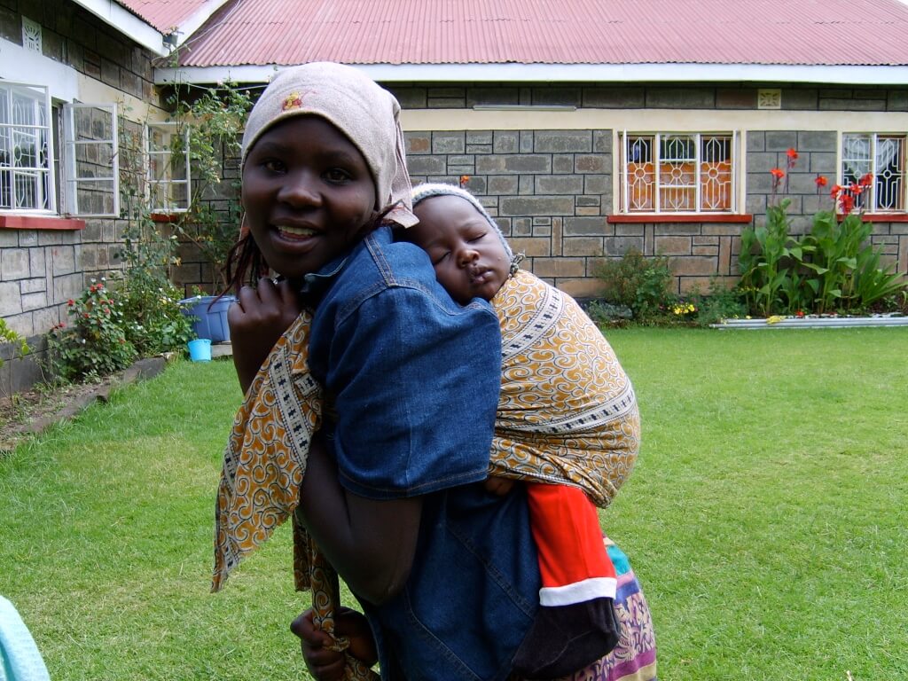 a teenager with a young child on her back - the result of no school