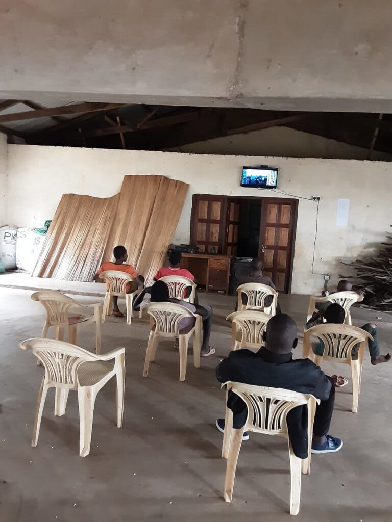 7 students watching lessons on a tv in Kenya.  Every day students come to William's church to watch lessons on a 32 inch screen