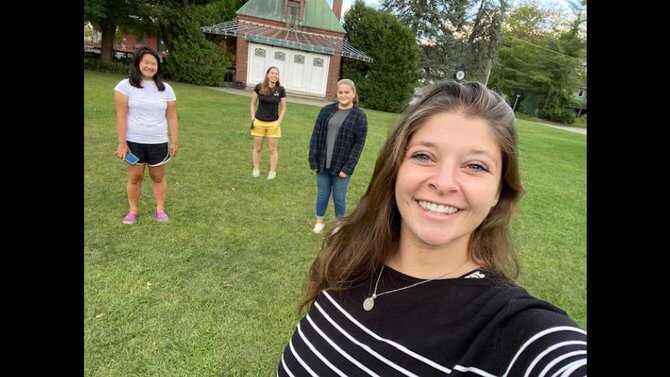Really Good News about these three students standing in a field with Tracy Guion, head of Harwood Students Making Change