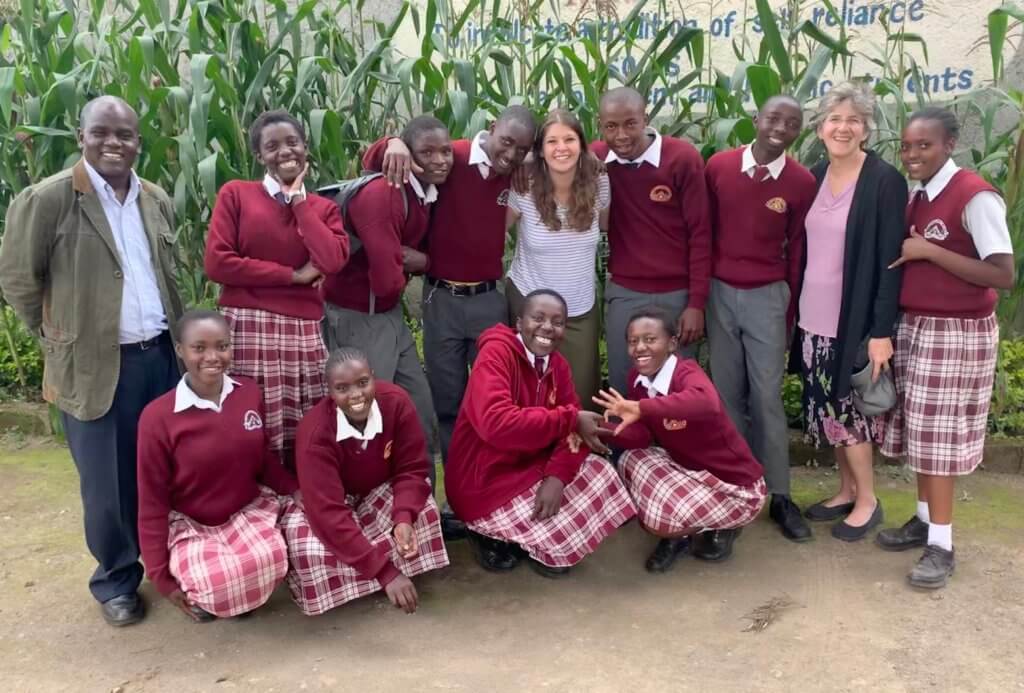 Kenyan secondary students in maroon uniforms standing together