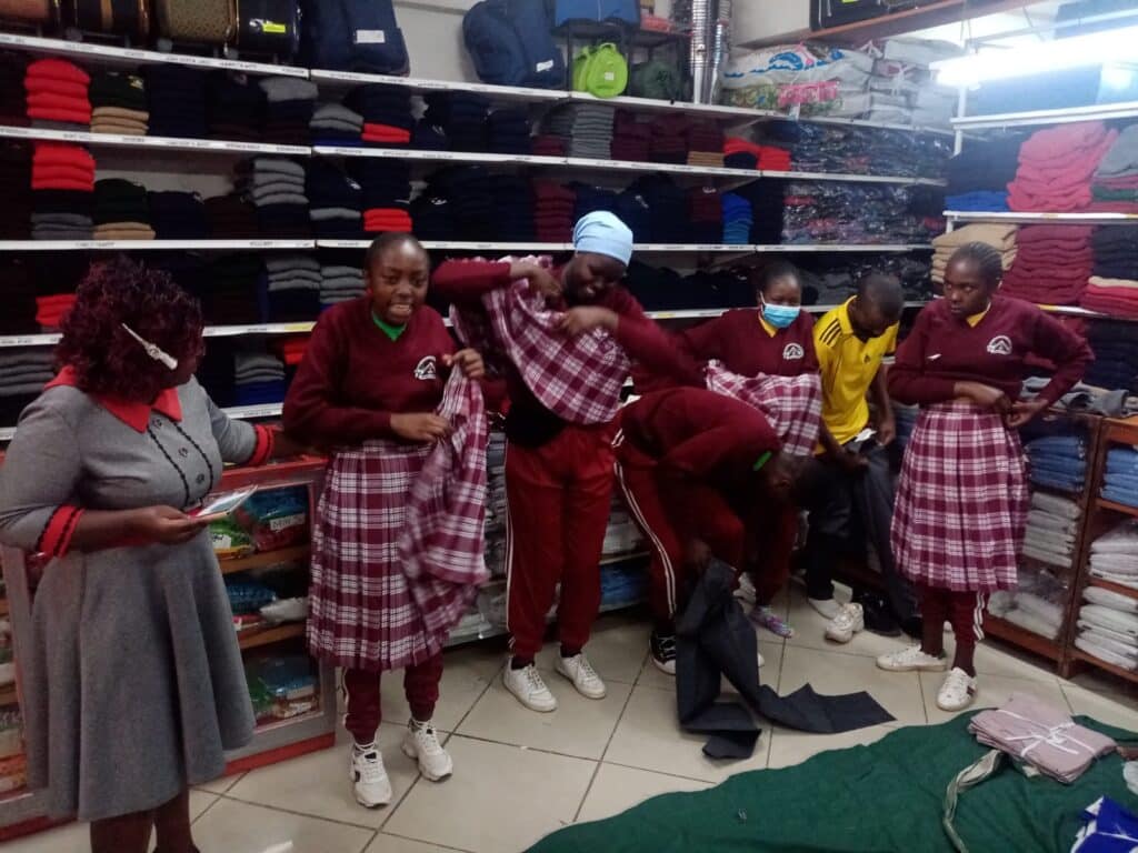 kenyan students trying on new school uniforms
