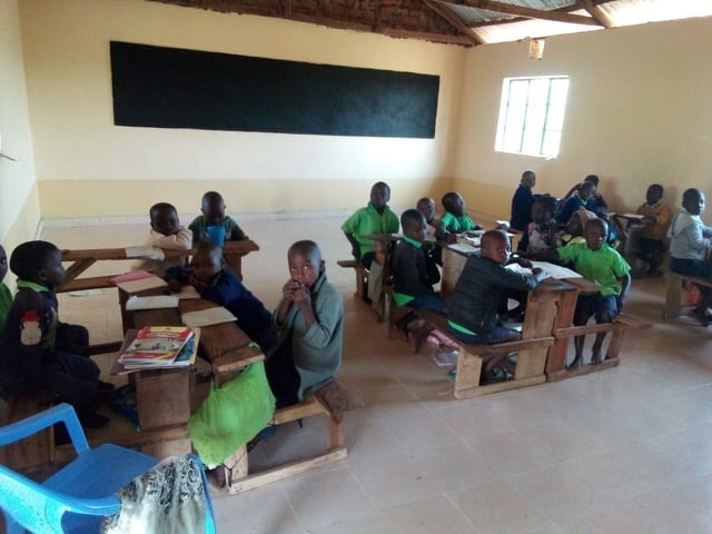 Children sitting at tables in newly painted classroom 